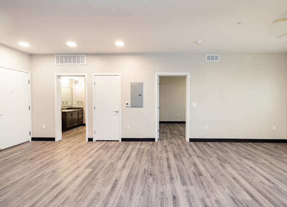 the living room of a new home with white walls and wood floors
