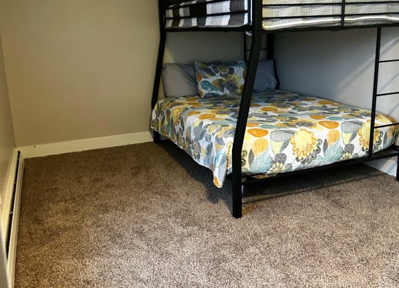 a bunk bed in a room with a carpet