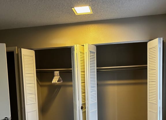 an empty closet with shutters on the doors