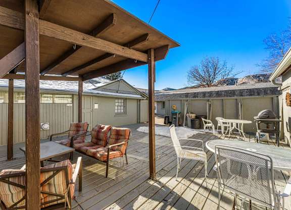 a patio with a table and chairs and a roof
