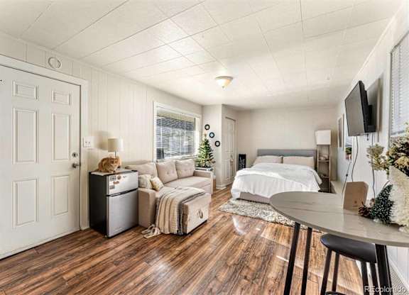 A bedroom with a bed, a couch, a chair, and a table.