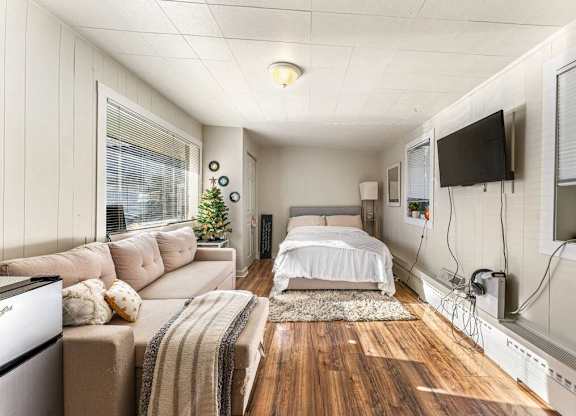a bedroom with a couch and a bed in a small room