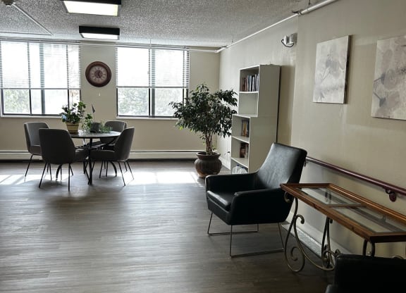 a living room with a table and chairs and a large window