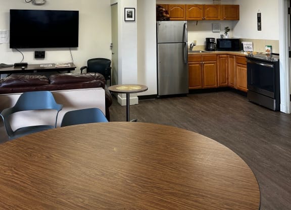 a kitchen and living room with a ceiling fan and a table