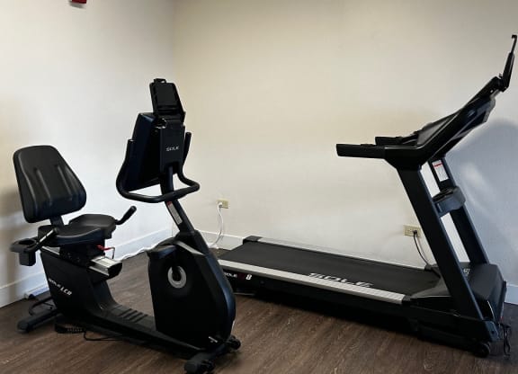 a gym with an exercise bike in the corner of a room