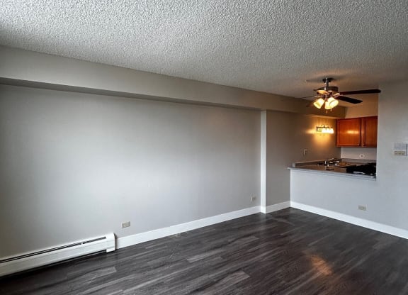 an empty living room with wood floors and a ceiling fan