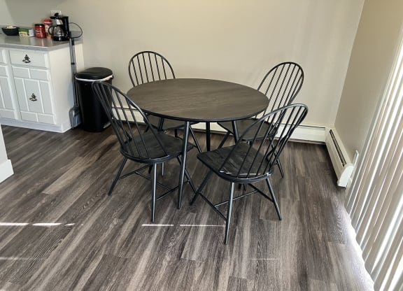 a dining room table with four chairs and a wooden floor