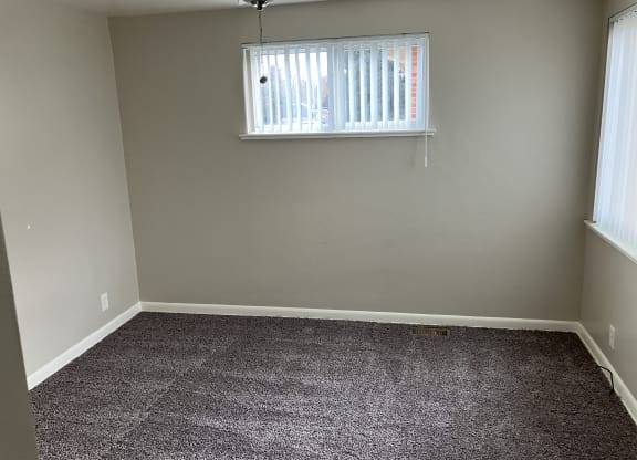 an empty room with carpet and a window