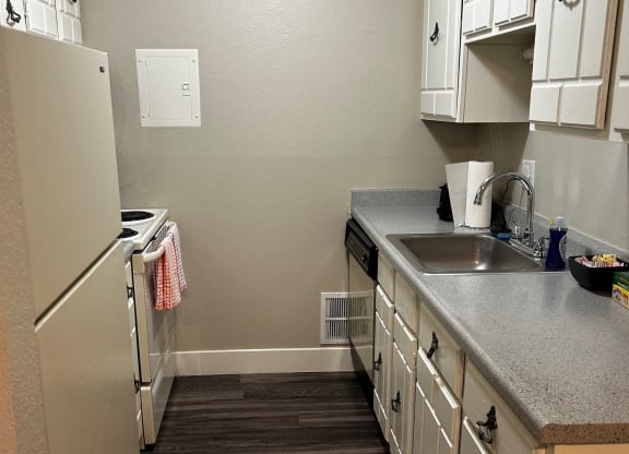 a kitchen with white cabinets and a refrigerator