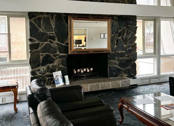 a living room with leather furniture and a stone fireplace