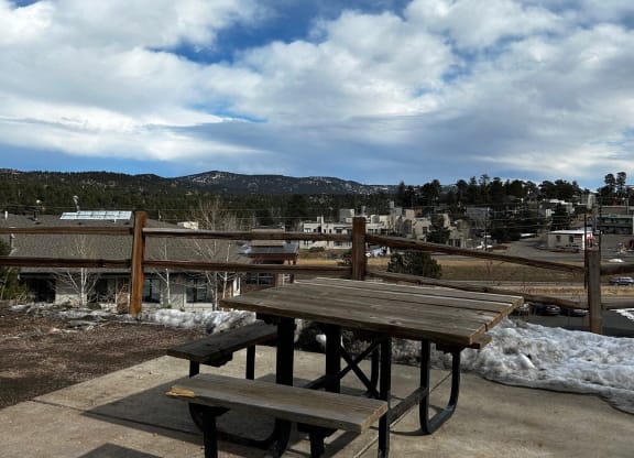 a picnic table with a view of a city and a cloudy sky