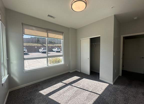 A sunny room with a car parked outside the window.