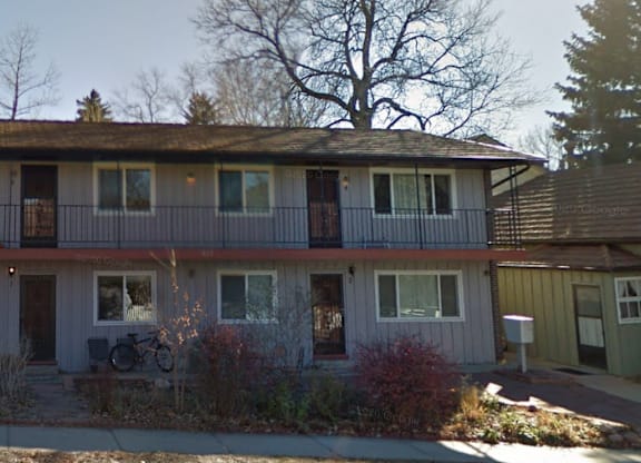 A two-story house with a balcony on the second floor.