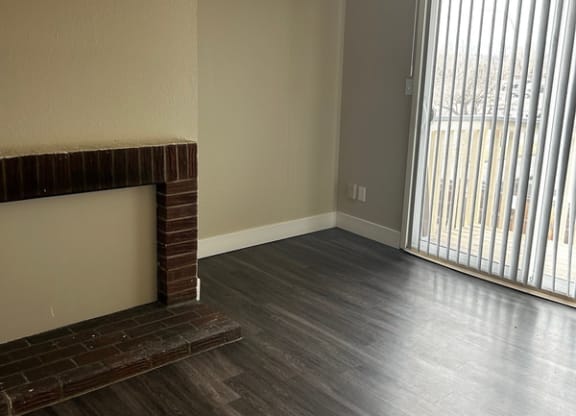 an empty living room with a fireplace and a sliding glass door