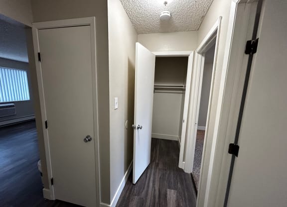 a hallway with two closets and a door to a closet