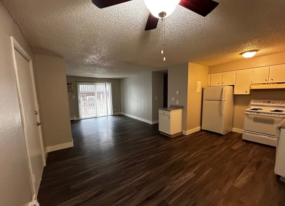 an empty kitchen and living room with a stove and refrigerator