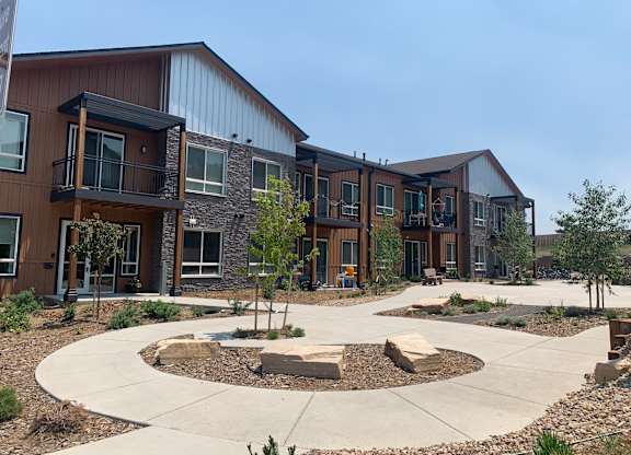 an exterior view of an apartment complex with walkways and landscaping