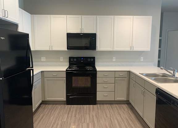 a kitchen with black appliances and white cabinets