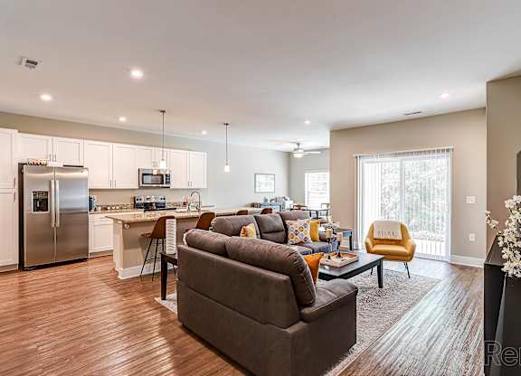 A modern living room with a grey couch and a wooden floor.
