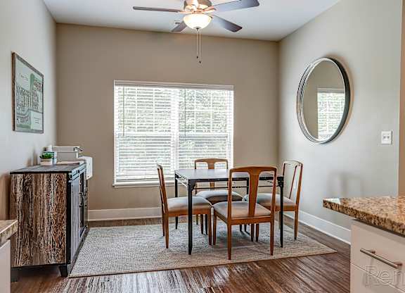 A kitchen with a dining table and chairs.