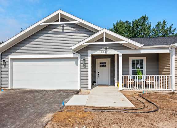 A two-story house with a garage and a driveway.