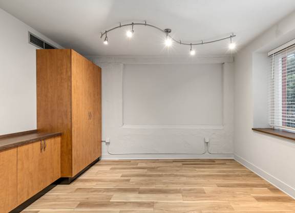 A room with wooden floors and a window with blinds.