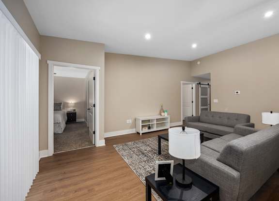 A living room with a grey couch and a black coffee table.