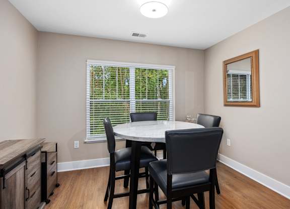 A dining room with a table and chairs.