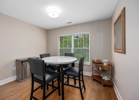 A dining room with a table and chairs.