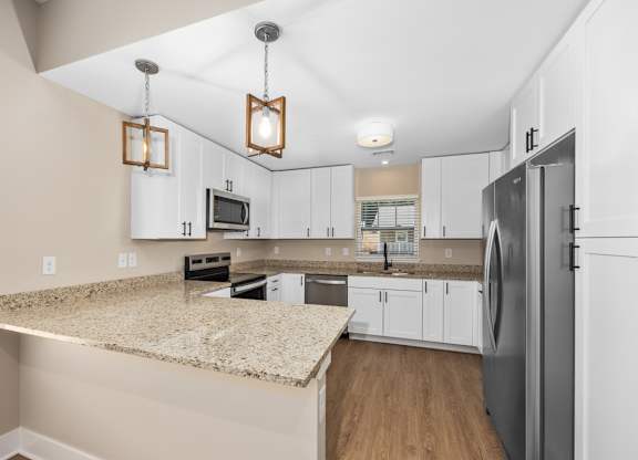 A kitchen with a granite countertop and a refrigerator.