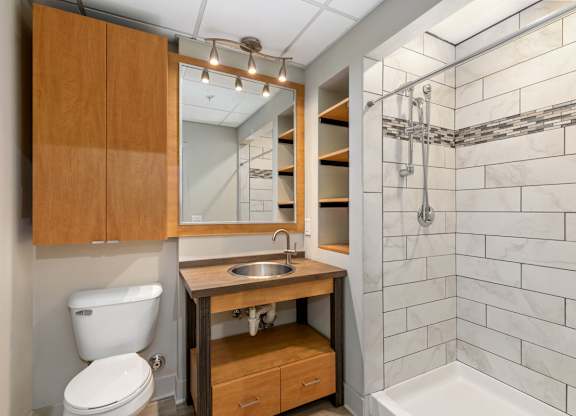 A bathroom with a toilet, sink, and a mirror.