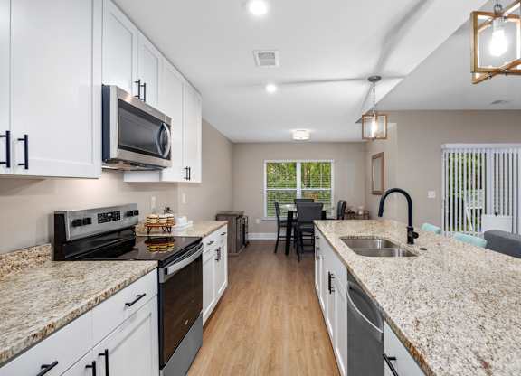 A kitchen with granite countertops and white cabinets.
