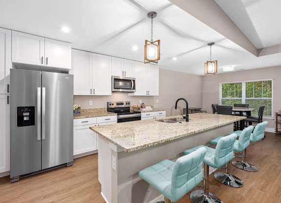 A kitchen with a refrigerator, microwave, and sink.