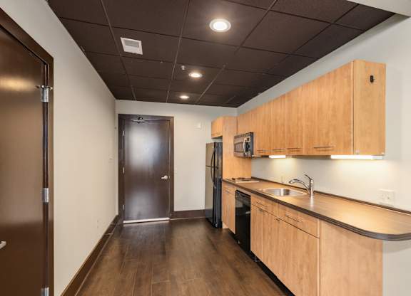 A kitchen with a sink, stove, and refrigerator.