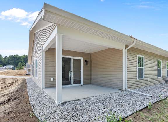 A house under construction with a gravel driveway.