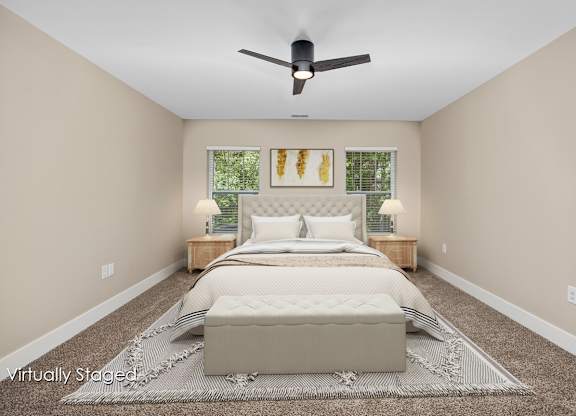 A bedroom with a large bed and a ceiling fan.