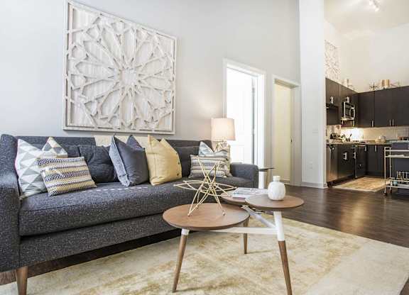 A grey couch with a wooden table in front of it.