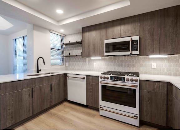 A modern kitchen with a white oven and microwave above it.