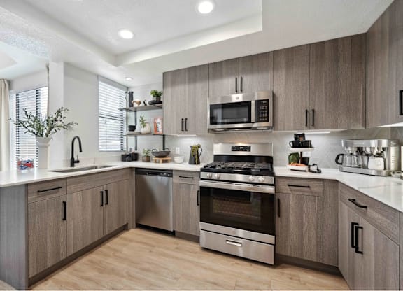 A modern kitchen with wooden cabinets and stainless steel appliances.