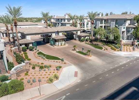 A sunny day at a residential complex with palm trees and a clear blue sky.