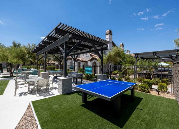 clubhouse with ping pong table and patio with chairs and a pergola