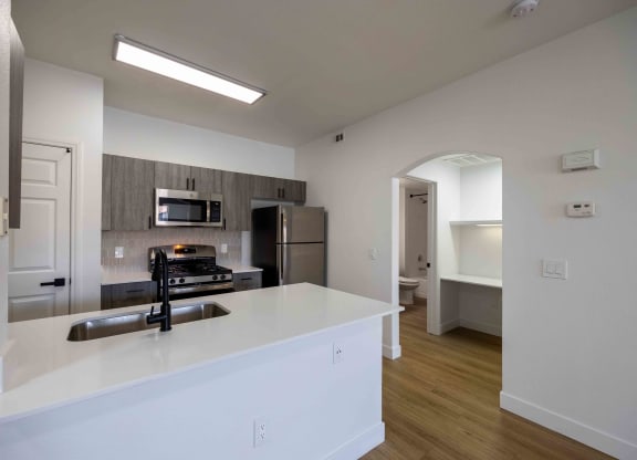 a kitchen with a large counter top and a stainless steel refrigerator