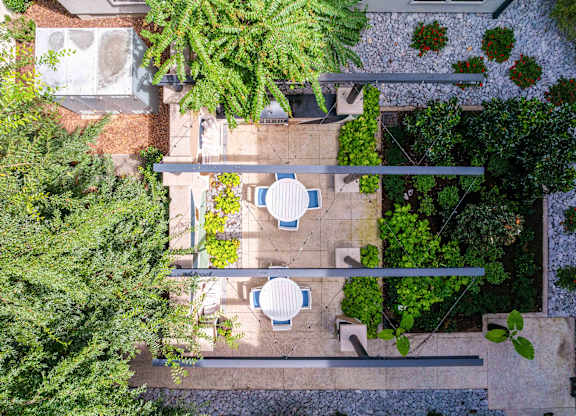 a birdseye view of a garden with tables and chairs and plants