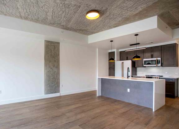 an empty living room and kitchen with a counter top and