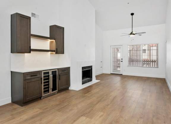 A spacious living room with a fireplace and wooden floors.