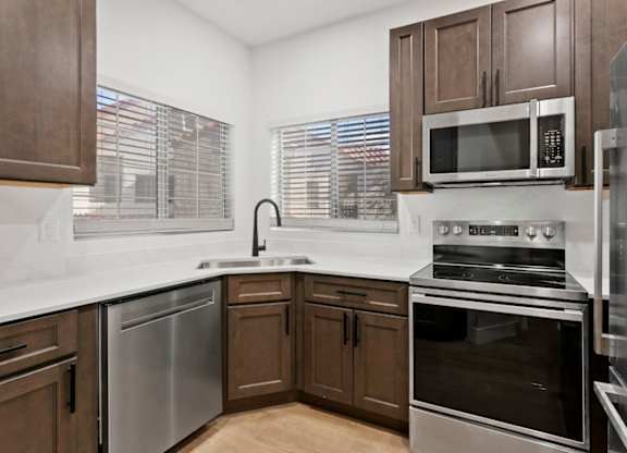 A kitchen with brown cabinets and stainless steel appliances.