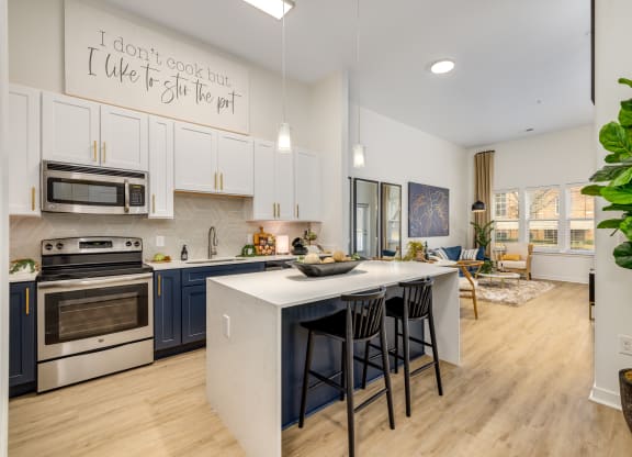A greatroom and kitchen with center island, offered at Midtown 205, recognized as best apartments in Charlotte, NC.