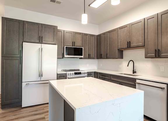 a kitchen with a large island and stainless steel appliances
