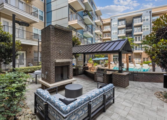 a patio with a fireplace and a pool in front of an apartment building