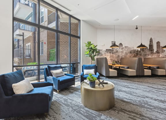 a large living room with blue couches and chairs and a large window